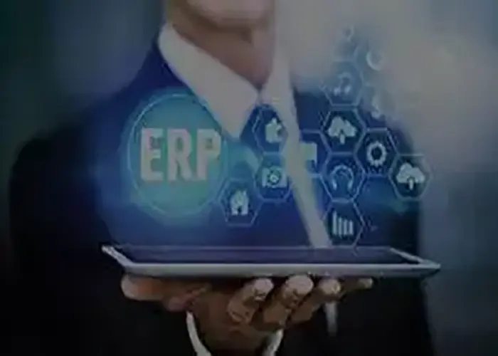 Business professional holding a tablet with digital ERP icons and technology graphics, representing Ambit’s recognition on CIO Review Magazine’s cover as one of the Top 20 Most Promising ERP and CRM Solution Providers.